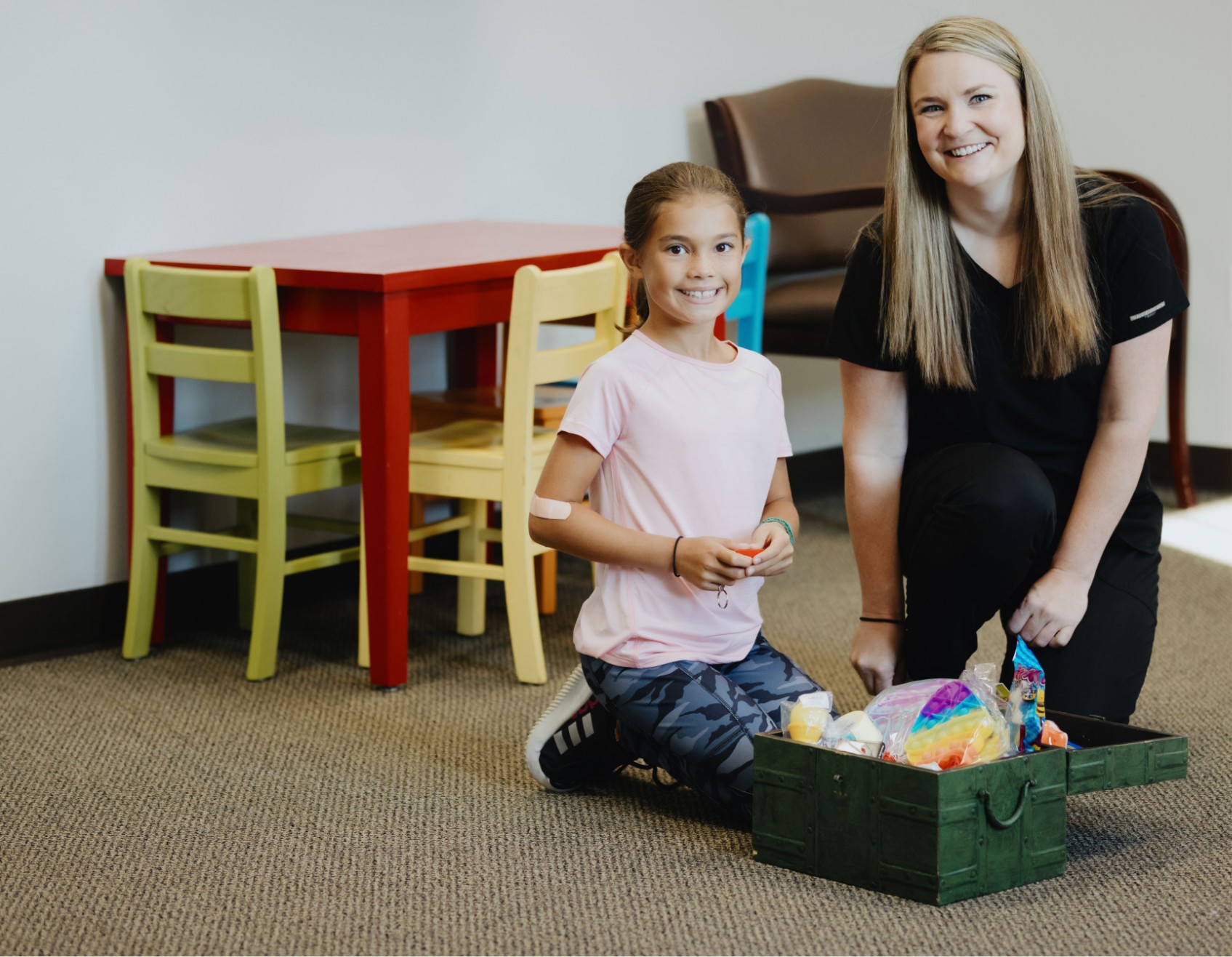 dental assistant and a girl sitting on the floor with a basket