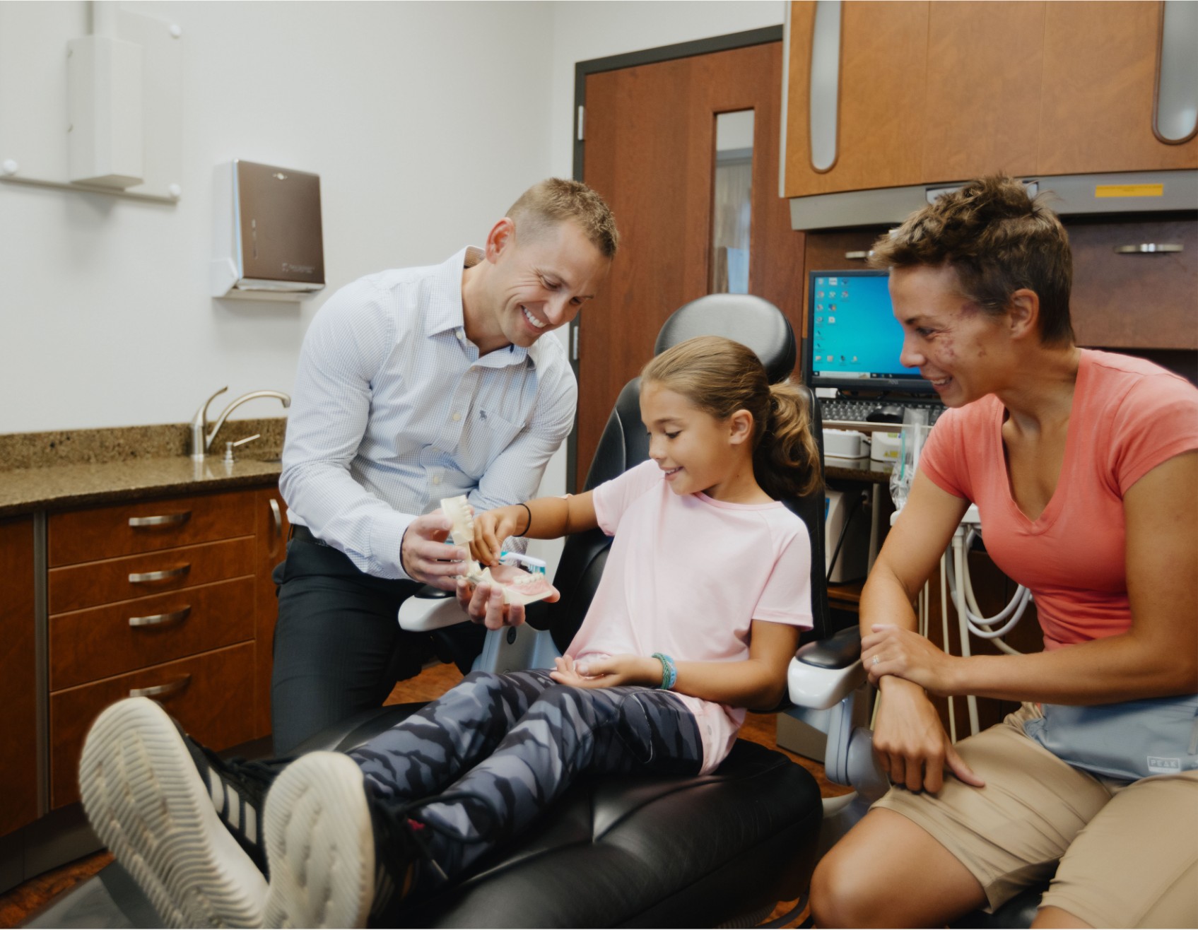 Dr. Gallup smiling with two female patients