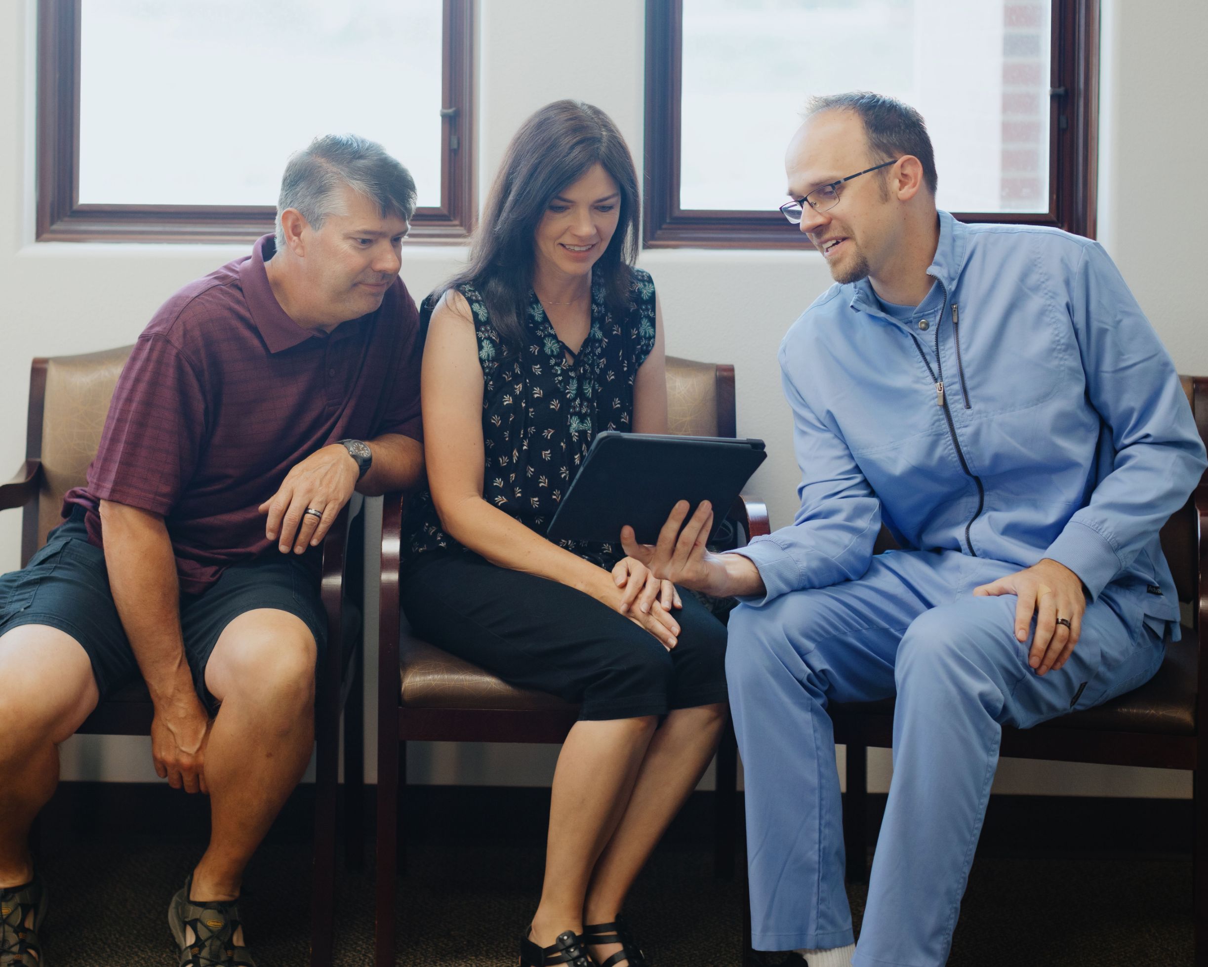 Dr, Milmont showing information on iPad to two patients