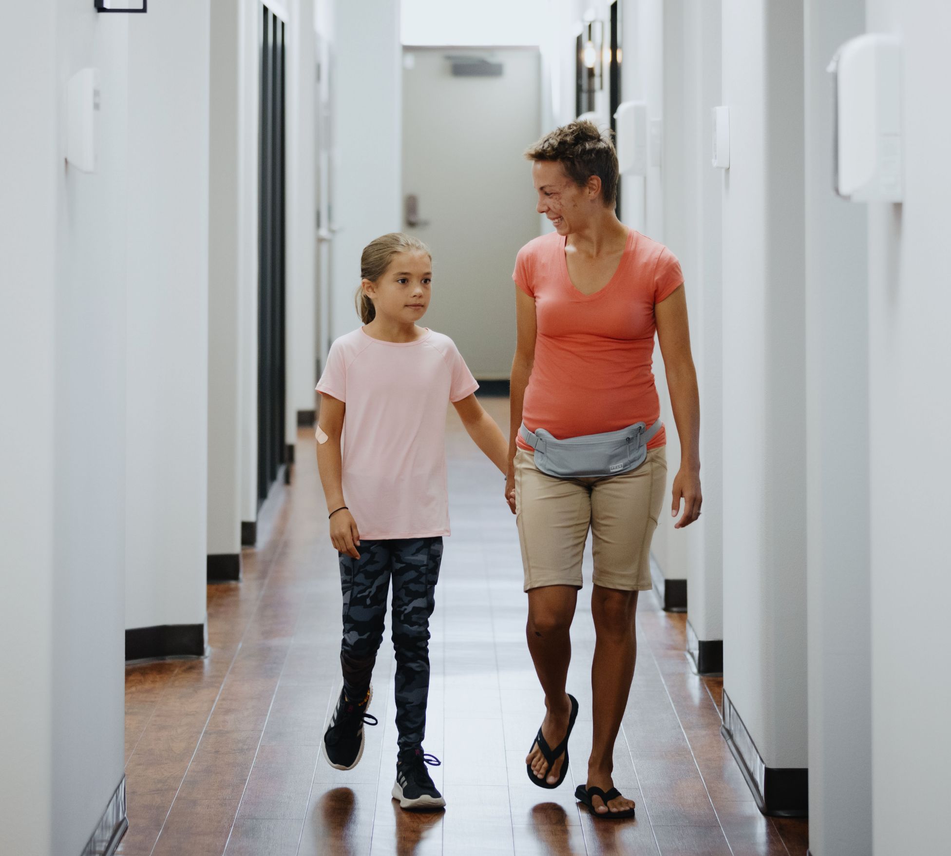 two female patients holding hands and walking