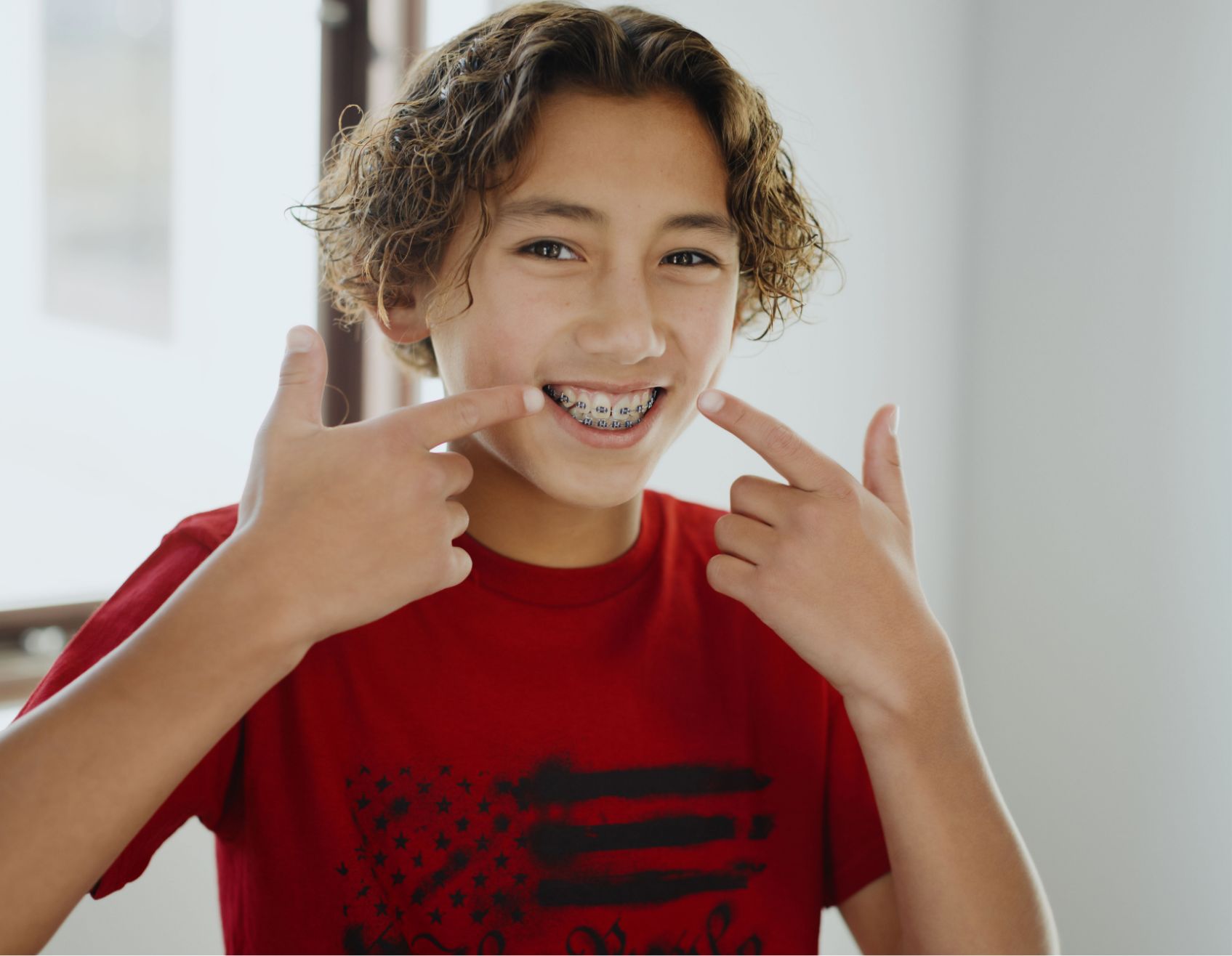a boy smiling and holding up his fingers